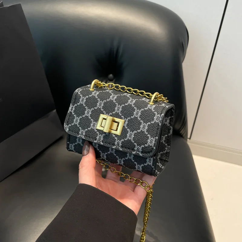 The Mini – Compact Women's Mini Handbag in stylish black pattern with gold chain, perfect for modern fashion.